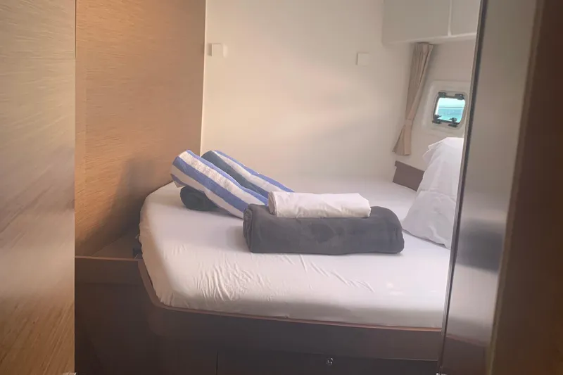 Slide: The Image of Cozy cabin interior of 2019 Lagoon 42 yacht with neatly arranged bedding. - 16