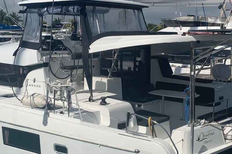 Slide: The Image of 2019 Lagoon 42 catamaran docked, featuring spacious deck and modern design. - 2