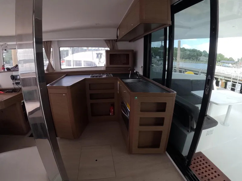 Slide: The Image of Interior of a 2019 Lagoon 42 catamaran featuring a modern kitchen and outdoor view. - 24