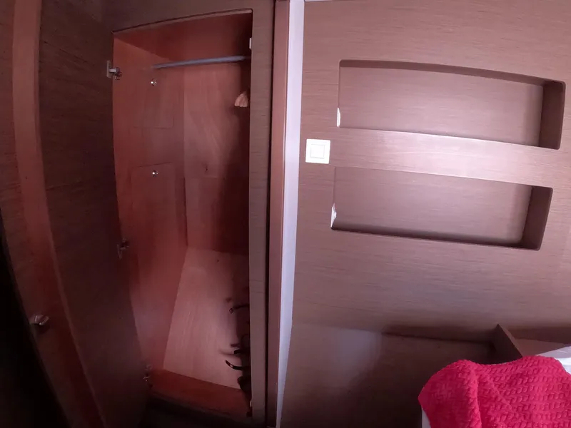Slide: The Image of Interior of 2019 Lagoon 42 yacht showing wooden closet and wall shelves. - 31