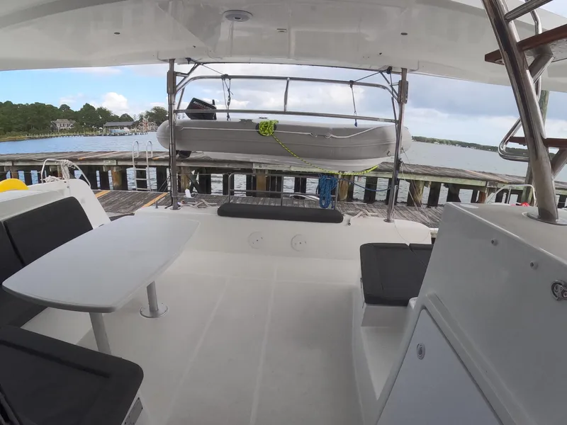 Slide: The Image of 2019 Lagoon 42 catamaran deck with seating, table, and docked view. - 35