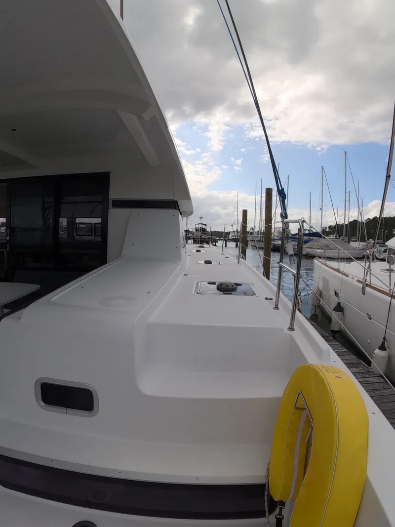 Slide: The Image of 2019 Lagoon 42 catamaran docked at marina under cloudy sky. - 39