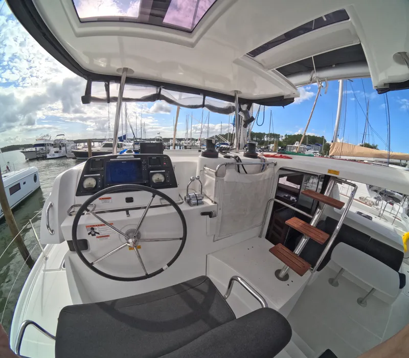Slide: The Image of Cockpit of a 2019 Lagoon 42 catamaran with steering wheel and navigation equipment. - 44