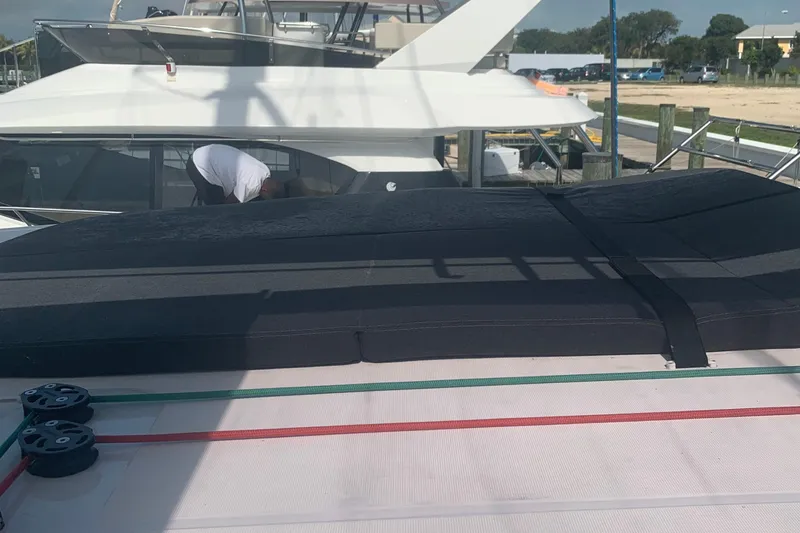 Slide: The Image of 2019 Lagoon 42 catamaran docked, featuring deck details and nearby boats. - 5