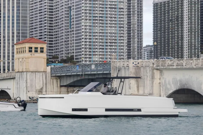 Slide: The Image of 2024 De Antonio Yachts D36 OPEN cruising near urban waterfront with skyscrapers. - 1