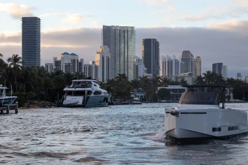 Slide: The Image of De Antonio Yachts D36 OPEN 2024 cruising near city skyline and waterfront buildings. - 4