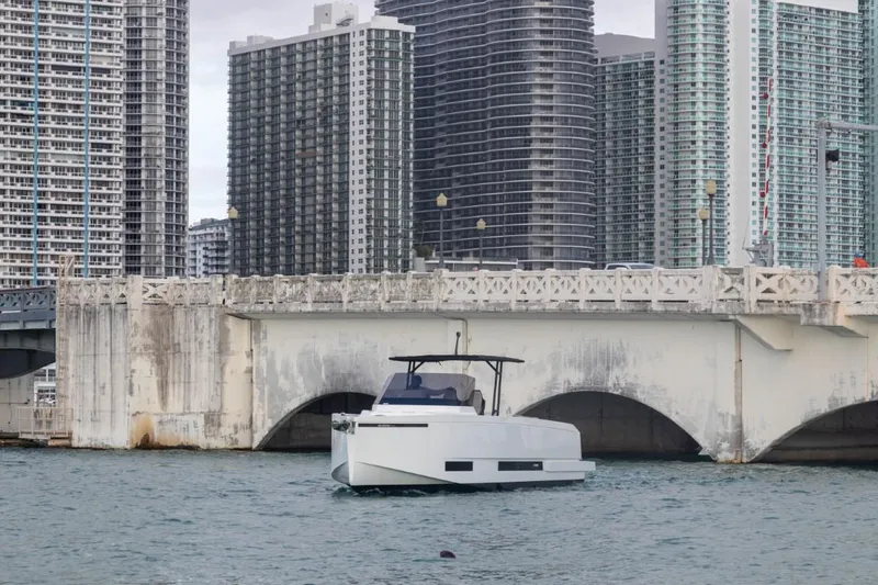 Slide: The Image of 2024 De Antonio Yachts D36 OPEN cruising near urban bridge and skyscrapers. - 2