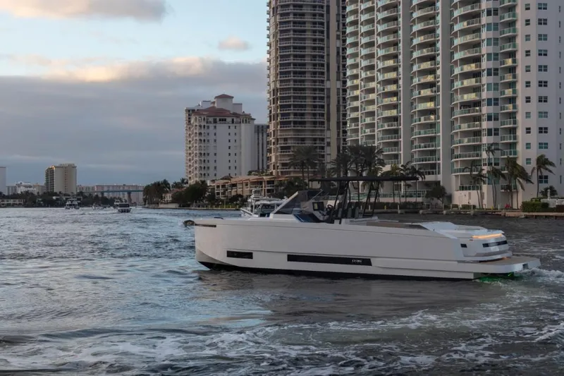 Slide: The Image of 2024 De Antonio Yachts D36 OPEN cruising near waterfront skyscrapers. - 6