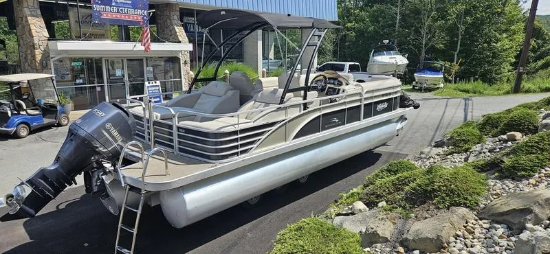 Slide: The Image of 2013 Bennington 2375 GCW pontoon boat on display, featuring a sleek design and powerful outboard motor. - 0