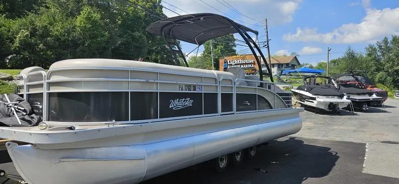 Slide: The Image of 2013 Bennington 2375 GCW pontoon boat parked at marina under clear sky. - 1