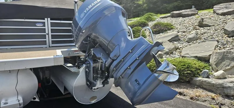 Slide: The Image of 2013 Bennington 2375 GCW boat with Yamaha outboard motor, parked on a driveway. - 5