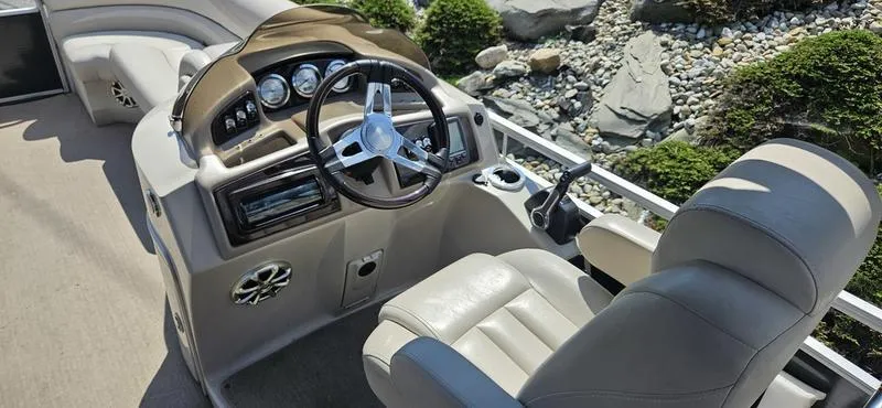 Slide: The Image of 2013 Bennington 2375 GCW boat interior with steering wheel and beige seating. - 6