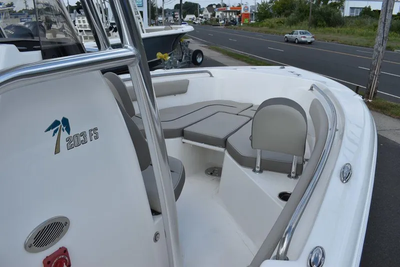 Slide: The Image of 2024 Key West 203 FS boat with cushioned seating, parked near a road. - 8