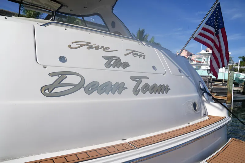 Slide: The Image of Sea Ray 510 Sundancer 2001 yacht with "The Dean Team" name, docked with American flag. - 11