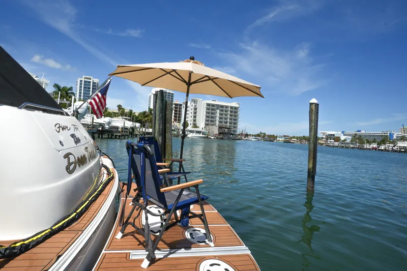 Slide: The Image of Sea Ray 510 Sundancer 2001 docked with chairs and umbrella, cityscape in background. - 30