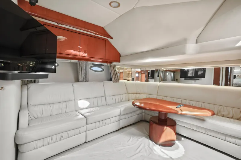 Slide: The Image of Luxurious interior of 2001 Sea Ray 510 Sundancer yacht with white leather seating and wooden table. - 48