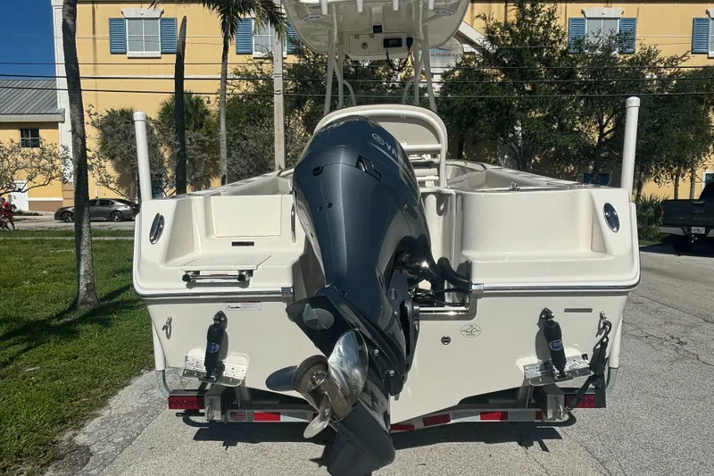 Slide: The Image of 2023 Sailfish 220 CC boat with outboard motor, parked on a sunny street. - 4