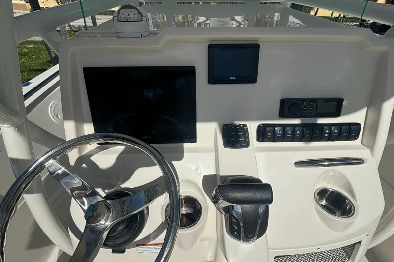 Slide: The Image of 2023 Sailfish 220 CC boat dashboard with steering wheel and electronic controls. - 9