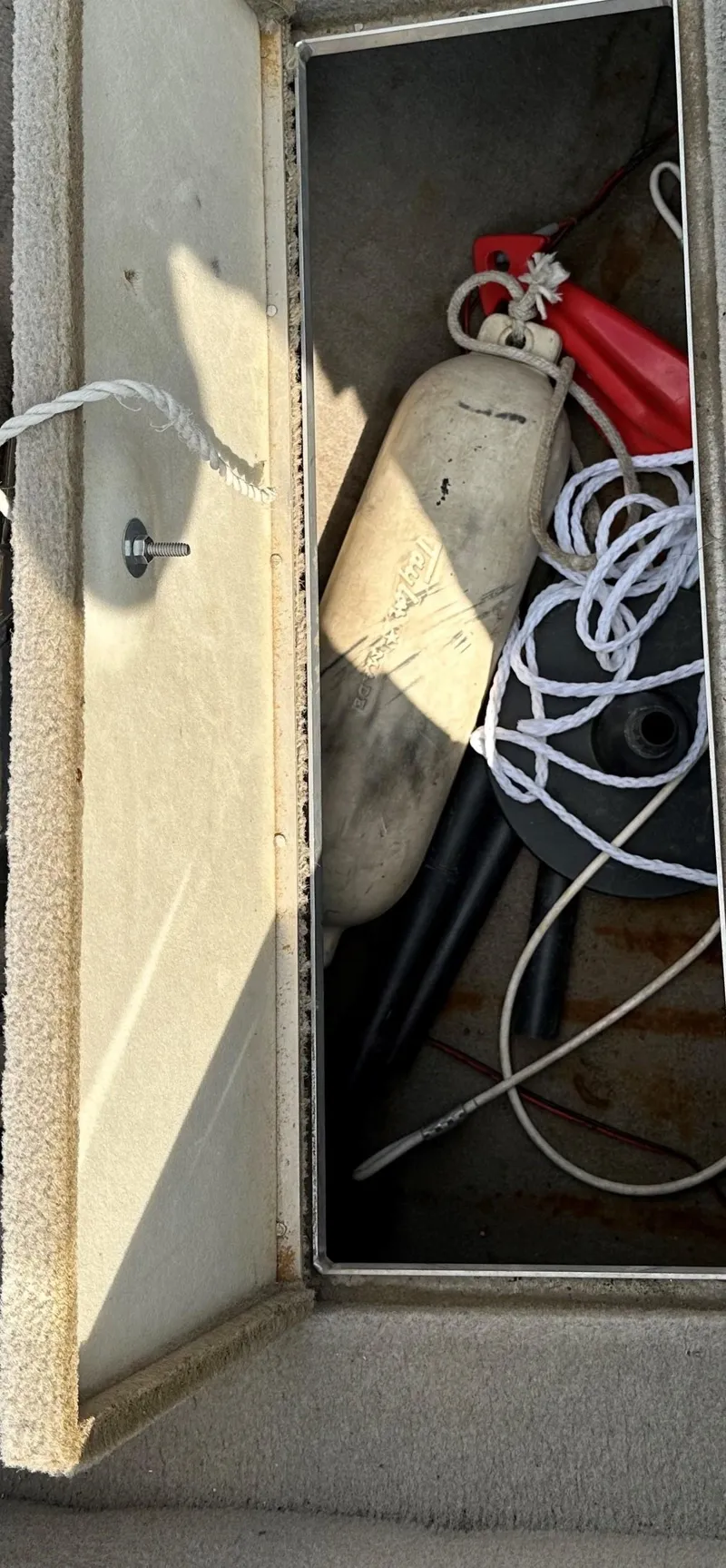 Slide: The Image of Storage compartment in a 1994 Lund 1850 Tyee boat with rope and fender. - 10