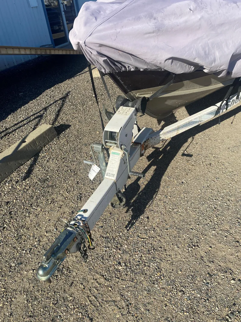 Slide: The Image of 1994 Lund 1850 Tyee boat on trailer, covered, parked on gravel. - 12