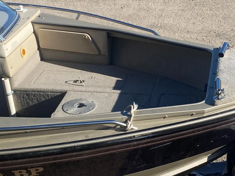 Slide: The Image of 1994 Lund 1850 Tyee boat interior with carpeted deck and storage compartments. - 15