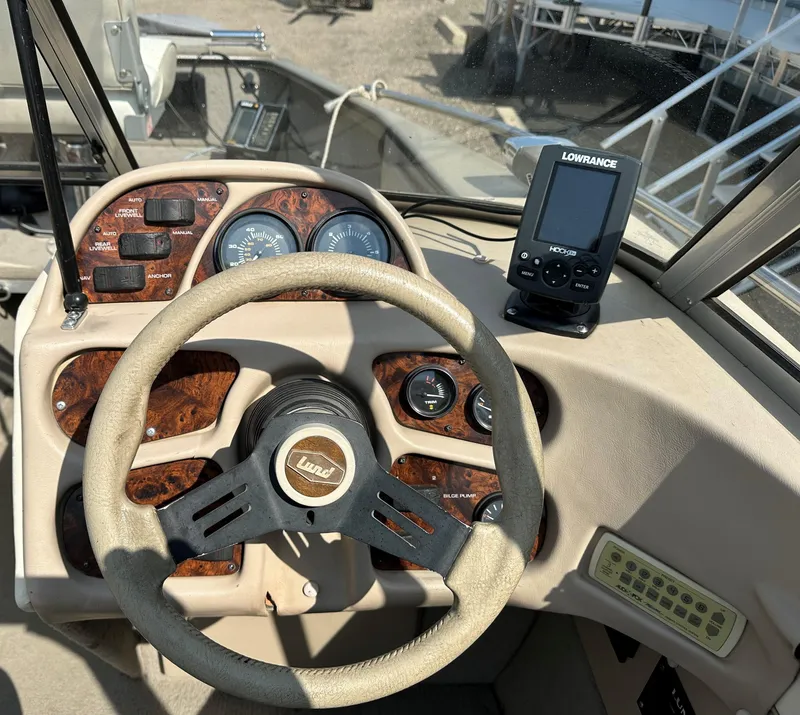 Slide: The Image of 1994 Lund 1850 Tyee boat dashboard with steering wheel and Lowrance fish finder. - 19