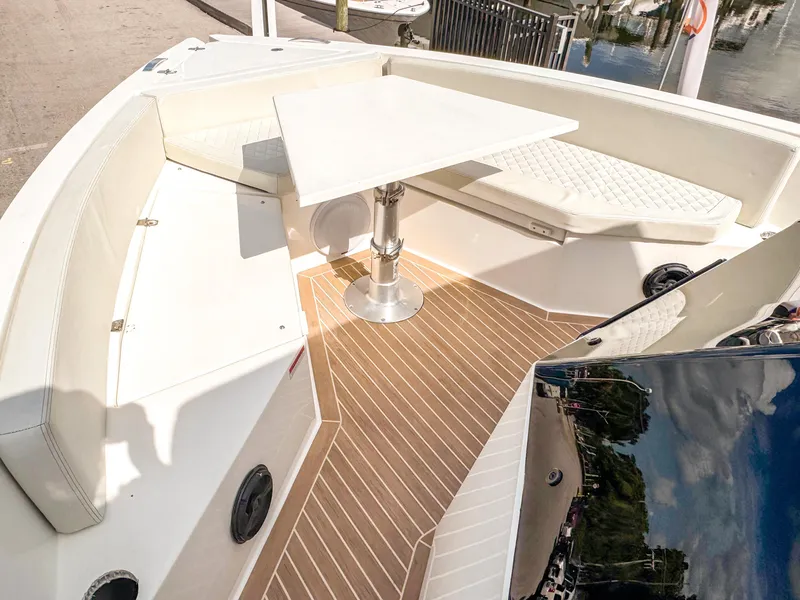 Slide: The Image of 2024 De Antonio Yachts D28 Open interior with seating and table, docked by the water. - 14