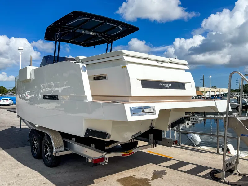 Slide: The Image of 2024 De Antonio Yachts D28 Open on trailer, dockside under blue sky. - 3