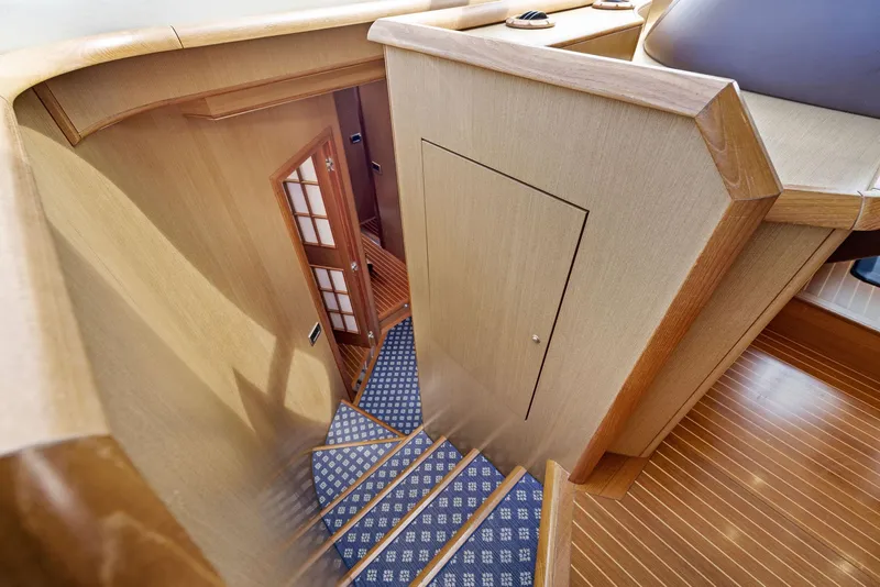 Slide: The Image of Interior staircase of 2008 Mochi Craft Dolphin yacht with wooden finish and carpeted steps. - 49