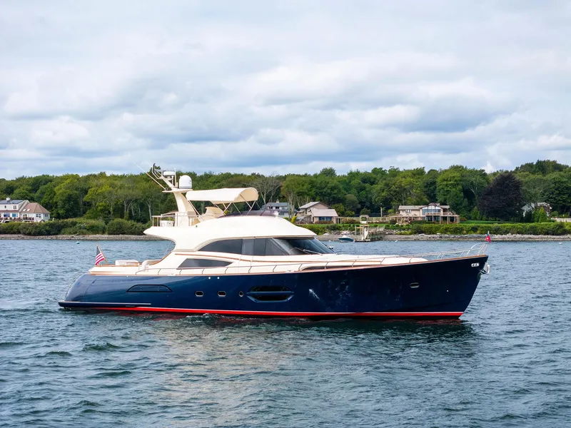 Slide: The Image of 2008 Mochi Craft Dolphin yacht on water, with scenic shoreline background. - 6