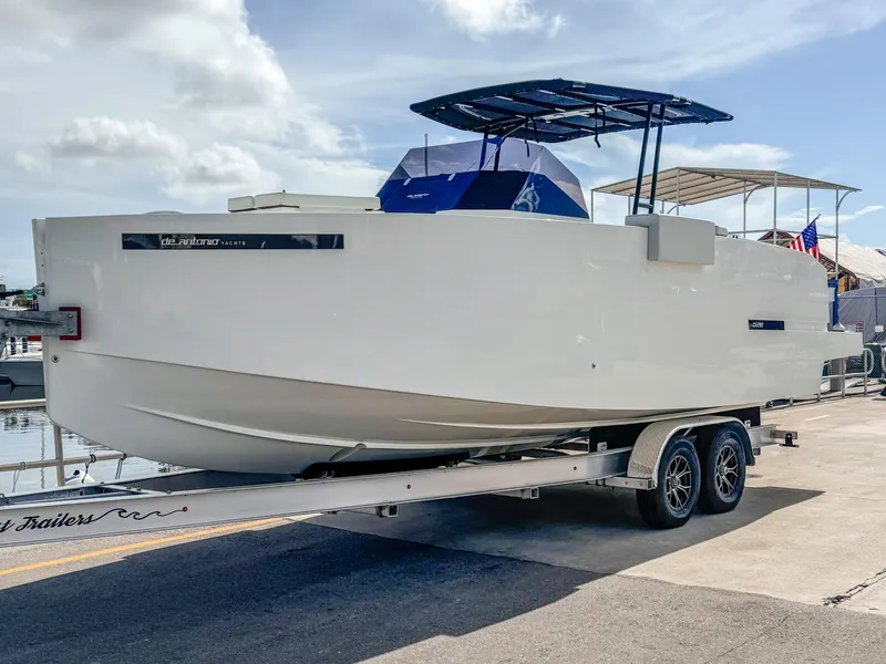 Slide: The Image of 2024 De Antonio Yachts D28 Open on trailer, sleek design, dockside setting. - 0