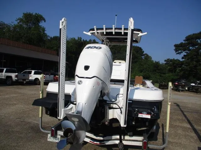 Slide: The Image of 2023 Caymas 26HB boat with powerful outboard motor, parked outdoors. - 8