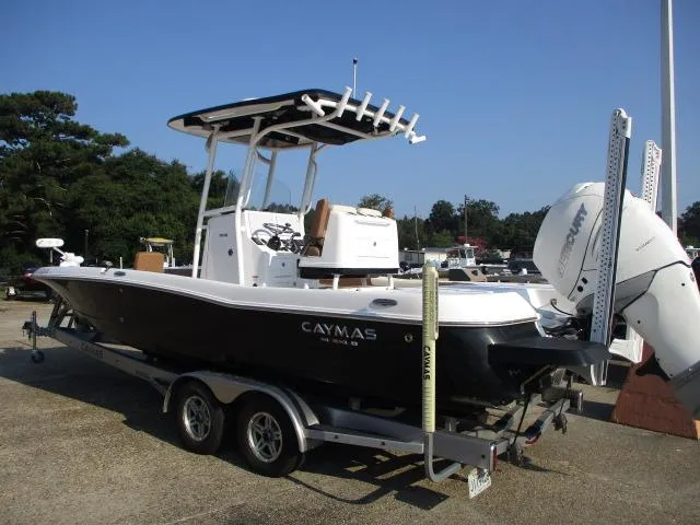 Slide: The Image of 2023 Caymas 26HB boat on trailer with outboard motor in marina setting. - 9