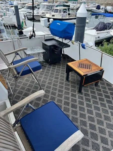 Slide: The Image of 1991 Carver 33 Aft Cabin deck with chairs and table, docked at marina. - 10