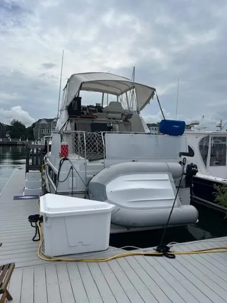 Slide: The Image of 1991 Carver 33 Aft Cabin yacht docked at marina with inflatable boat. - 3