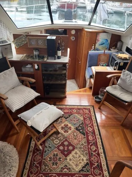 Slide: The Image of Interior of 1991 Carver 33 Aft Cabin with cozy seating and decorative rug. - 4