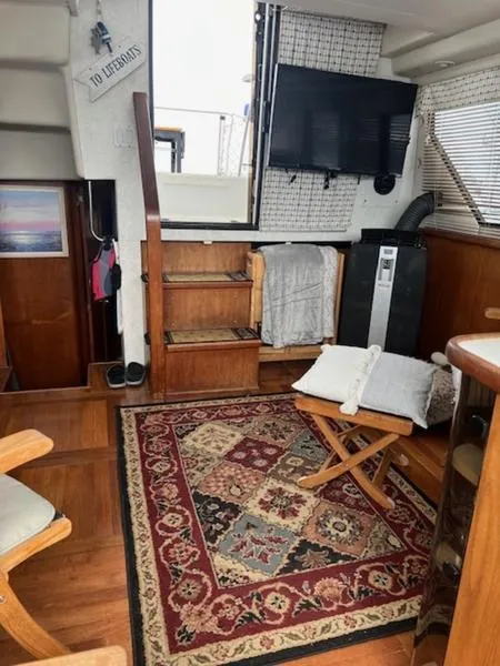 Slide: The Image of Cozy interior of 1991 Carver 33 Aft Cabin with TV, rug, and wooden furnishings. - 6