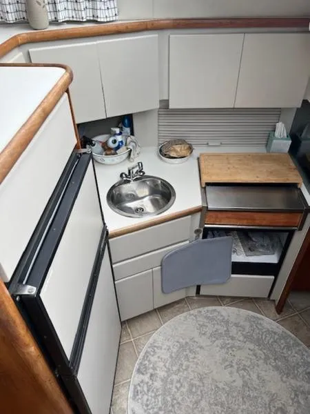 Slide: The Image of 1991 Carver 33 Aft Cabin kitchen with sink, fridge, and storage cabinets. - 8