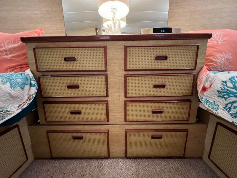 Slide: The Image of Vintage 1977 Bertram 42 Motor Yacht interior with wicker drawer cabinet and cozy bedding. - 24