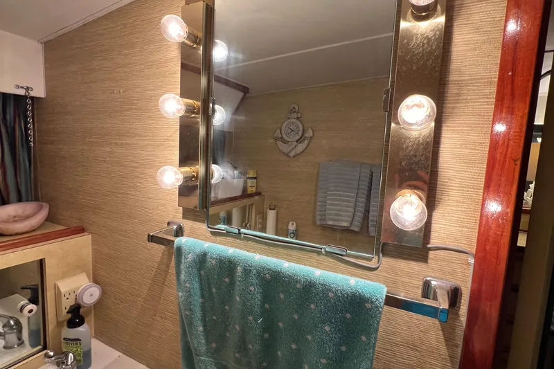 Slide: The Image of Bathroom vanity with mirror and lights on 1977 Bertram 42 Motor Yacht. - 26