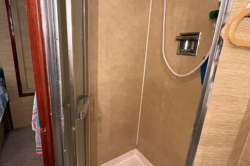 Slide: The Image of Shower area in a 1977 Bertram 42 Motor Yacht with beige walls and glass door. - 28
