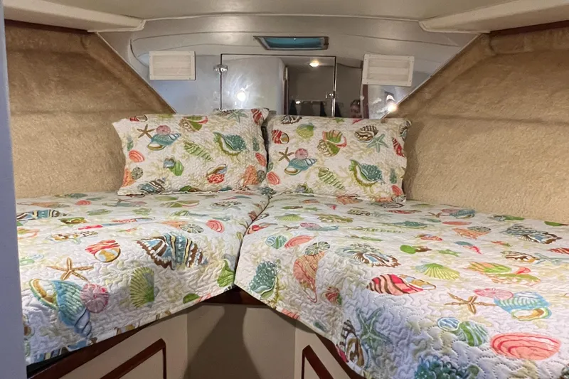 Slide: The Image of Cozy cabin interior of 1977 Bertram 42 Motor Yacht with seashell-themed bedding. - 29