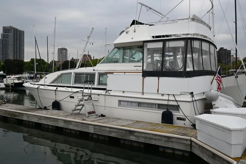 Slide: The Image of 1977 Bertram 42 Motor Yacht docked at marina with city skyline. - 3