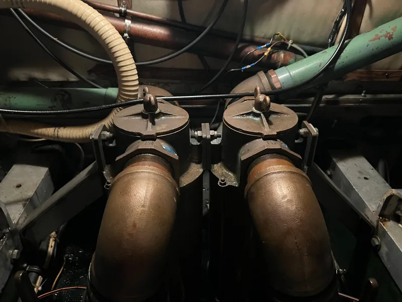 Slide: The Image of Engine room of a 1977 Bertram 42 Motor Yacht with visible pipes and fittings. - 34