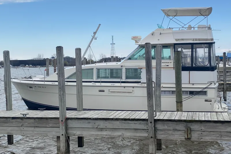 Slide: The Image of 1977 Bertram 42 Motor Yacht docked at a marina, side view. - 4