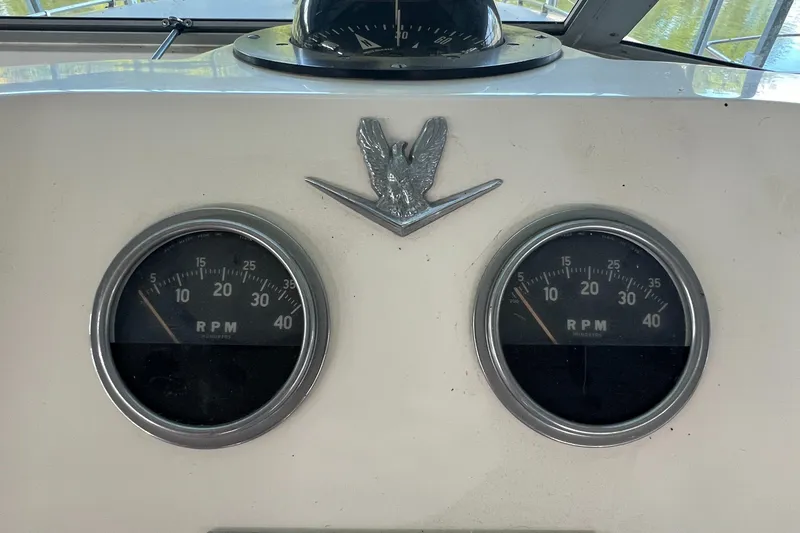 Slide: The Image of 1977 Bertram 42 Motor Yacht dashboard with RPM gauges and emblem. - 9
