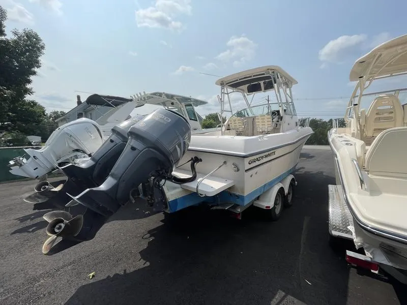 Slide: The Image of 2003 Grady-White 232 Gulfstream boat with outboard motor in a marina. - 6