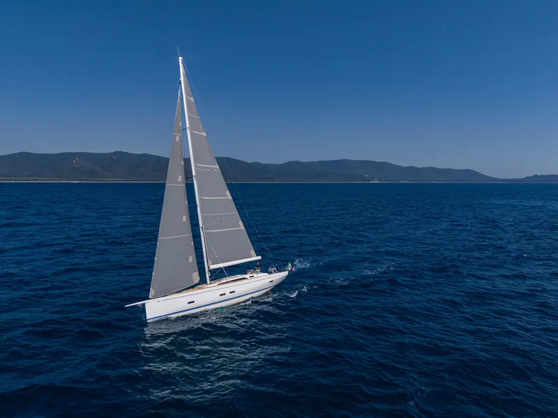 Slide: The Image of Grand Soleil 52 Performance 2025 sailing on open sea under clear blue sky. - 3