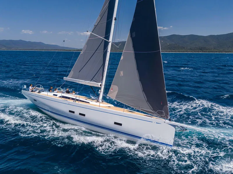 Slide: The Image of Grand Soleil 52 Performance 2025 sailing on open sea with mountains in background. - 7