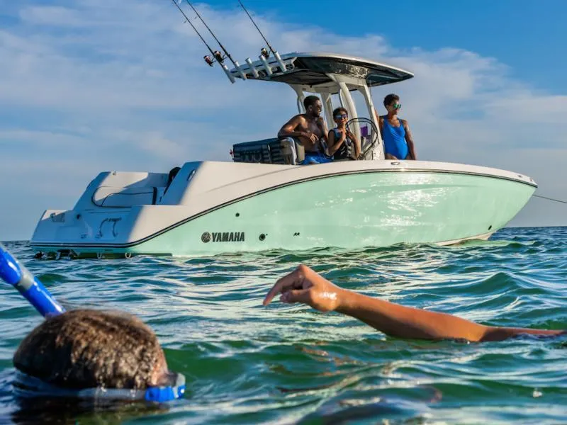 Slide: The Image of 2024 Yamaha Boats 252 FSH Sport on water with snorkelers nearby. - 7